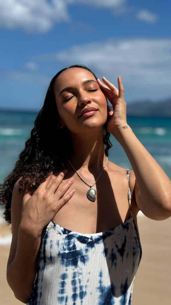 Model wearing ARIE blue indigo tie-dye dress on a Caribbean beach