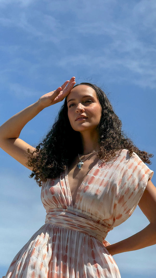 Model wearing LOVE pink tie-dye dress with smocked elastic waist