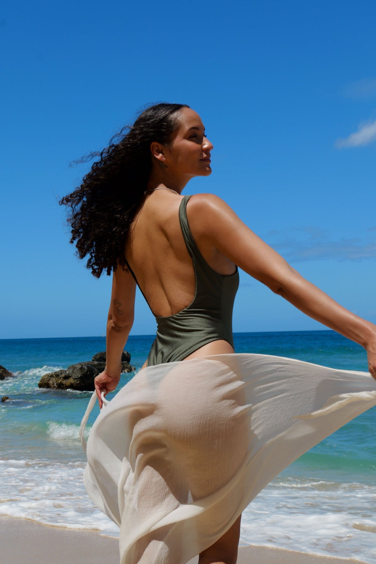 Model wearing the Cara one piece Bikini - Khaki with a white Sarong 