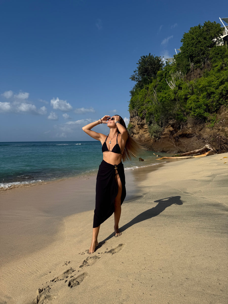 Model in PALM black sarong walking by the ocean