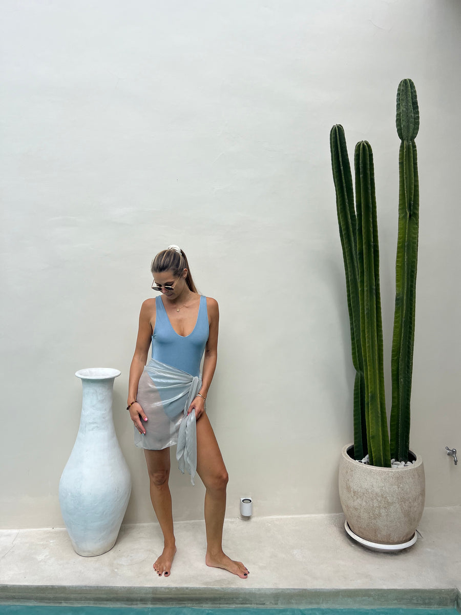 Model wearing ELA silver silk short sarong by the poolside