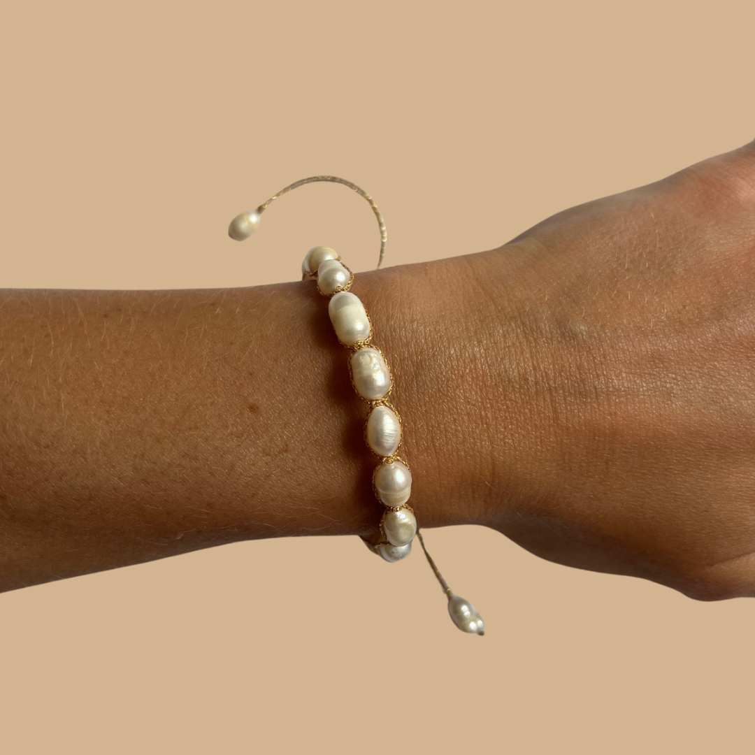 Modelo con Pulsera de perlas de agua dulce — detalles dorados