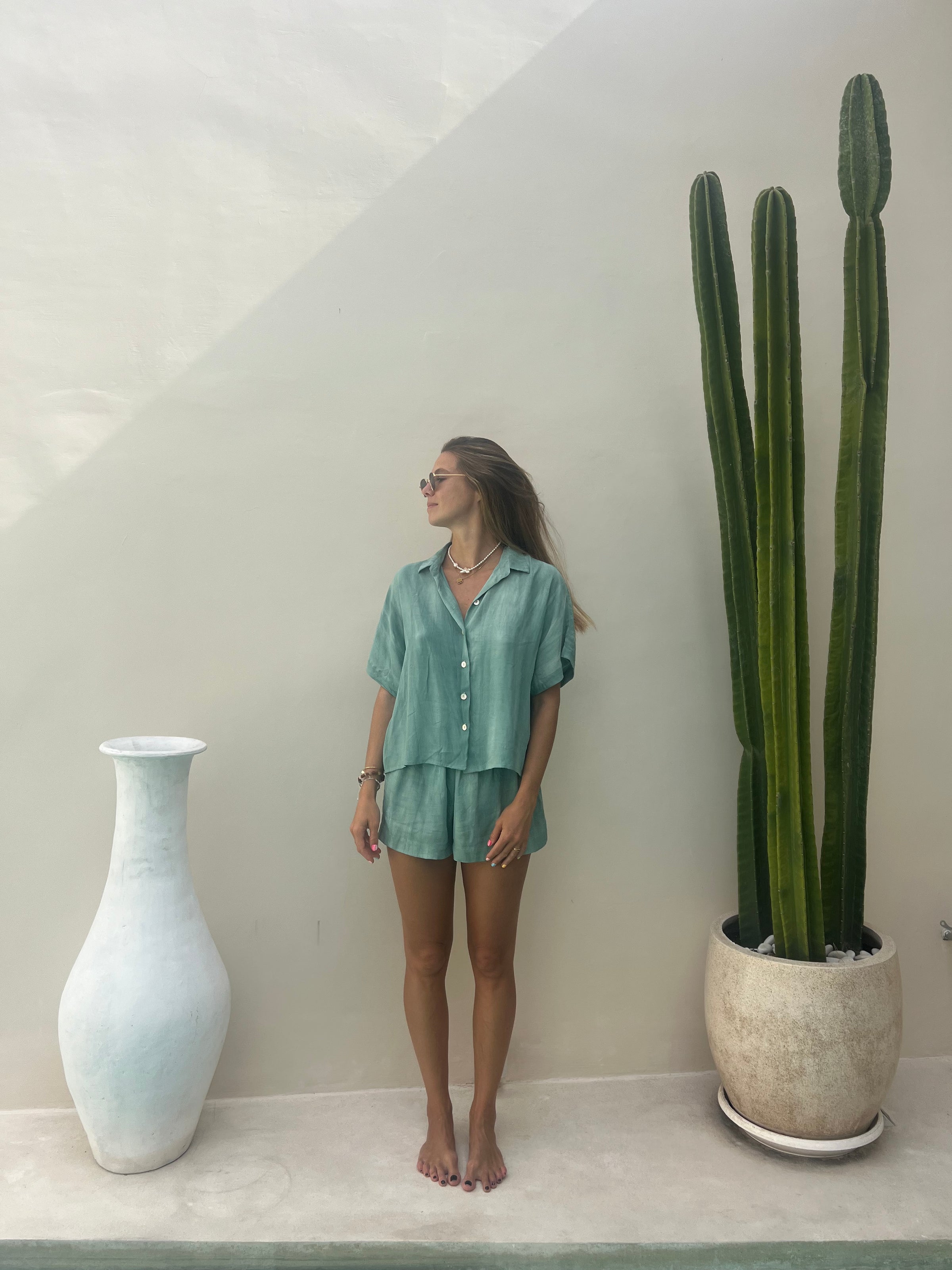 Model in REIA green shirt styled open over a bikini