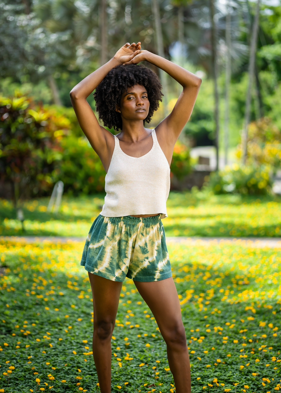 Movement pose showing the relaxed fit of BLISS green and yellow tie-dye shorts